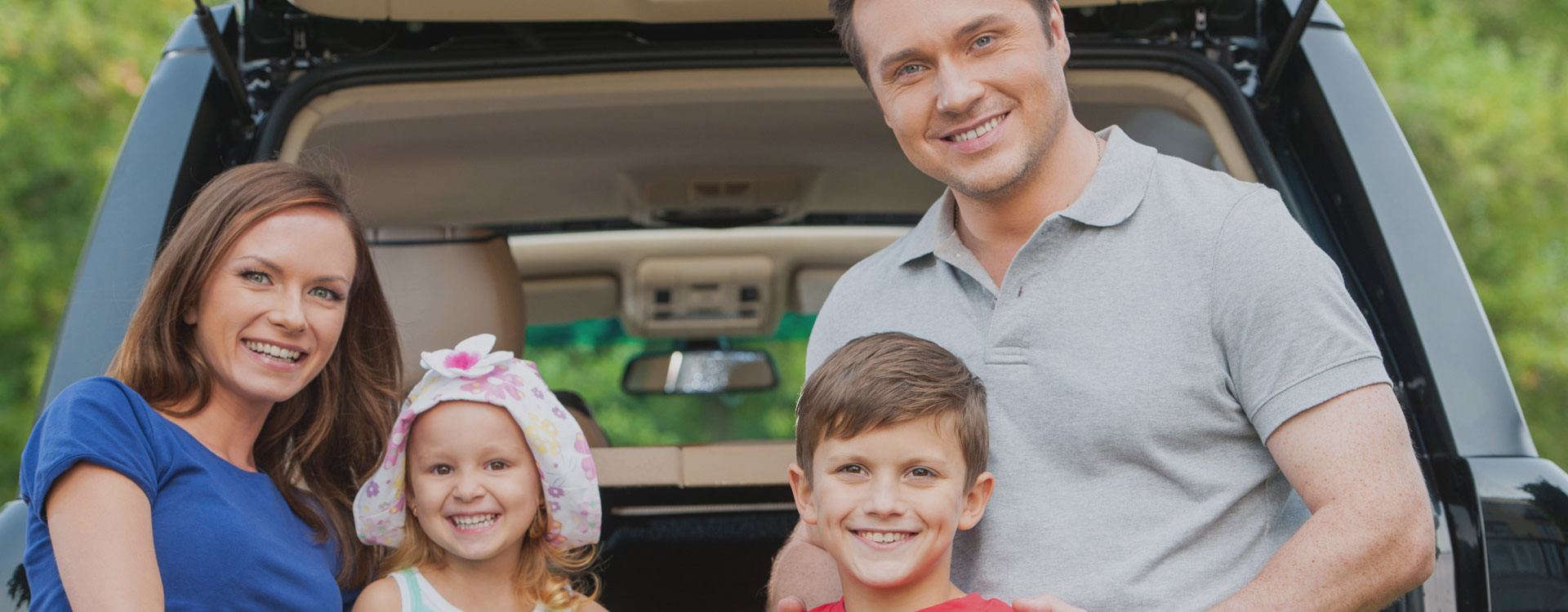 Happy family in front of car